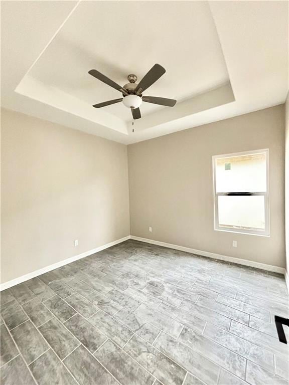 Spare room featuring a tray ceiling and ceiling fan