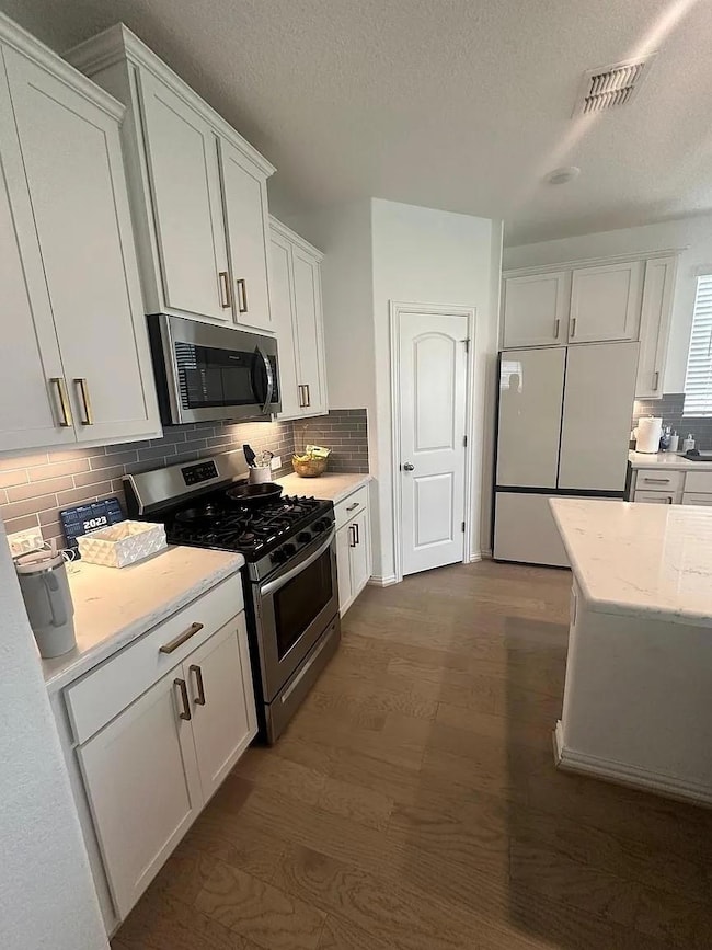Kitchen featuring dark wood-style flooring, stain