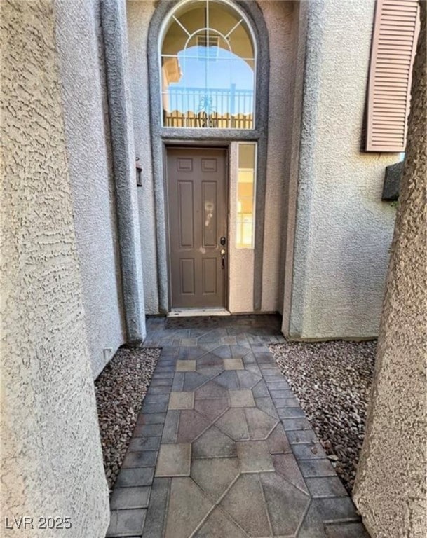 View of exterior entry featuring stucco siding