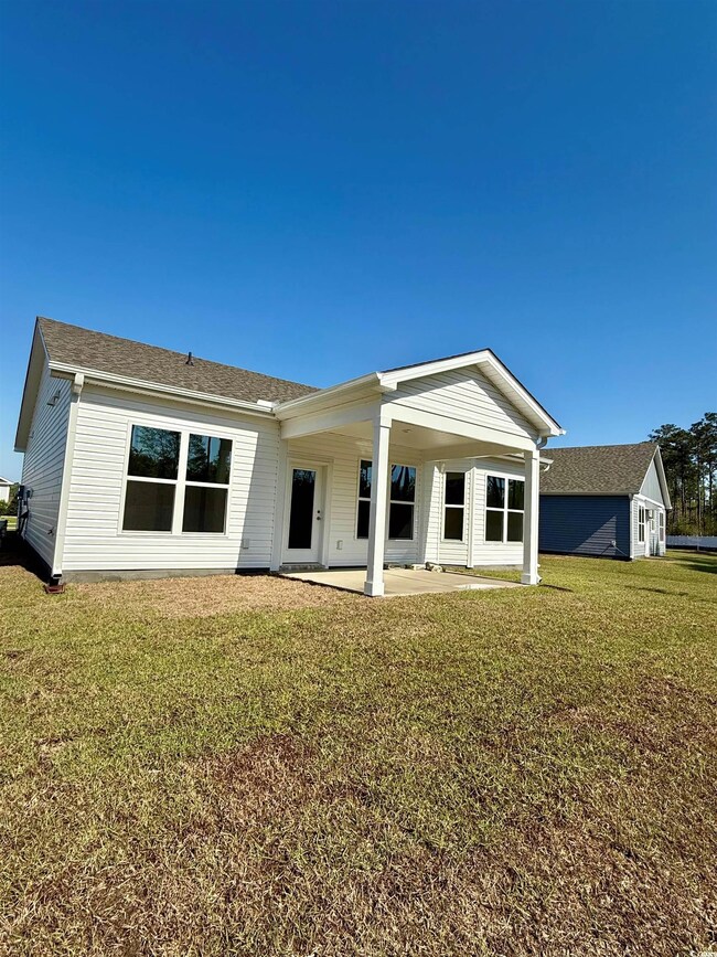 Back of property with a patio area and a lawn