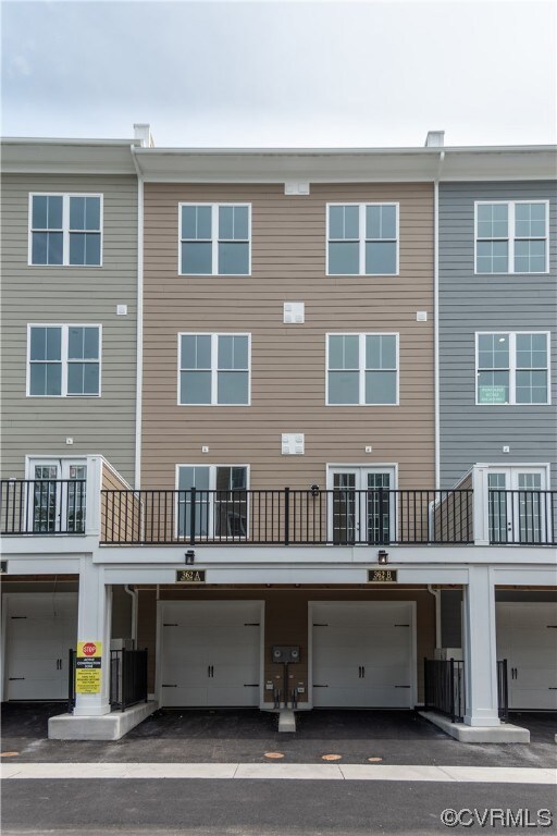 Rear of home featuring deck and 1-car garage