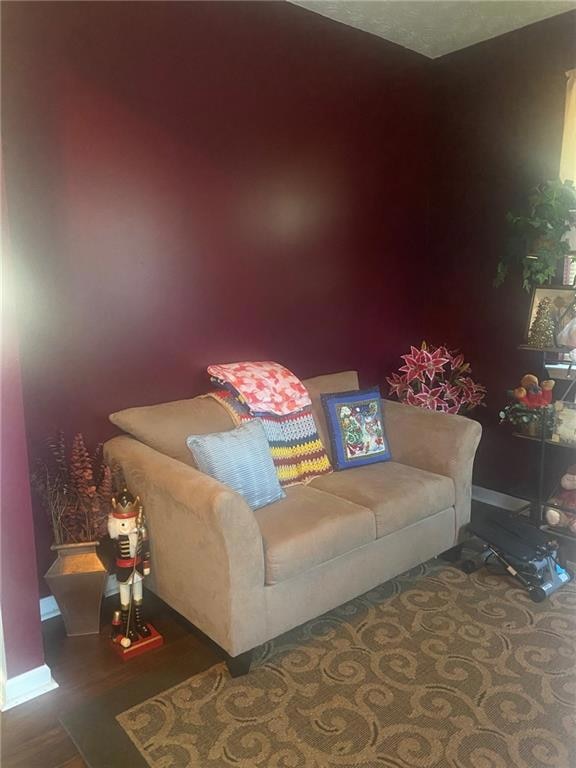 Sitting room featuring dark wood finished floors and baseboards