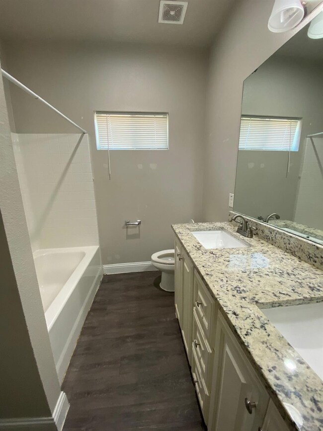 Full bathroom with visible vents, toilet, a sink, 