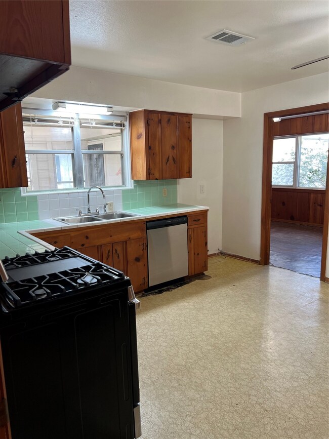 This kitchen features wood cabinetry, a large wind