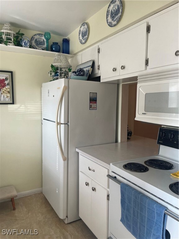 Kitchen with light countertops, freestanding refri
