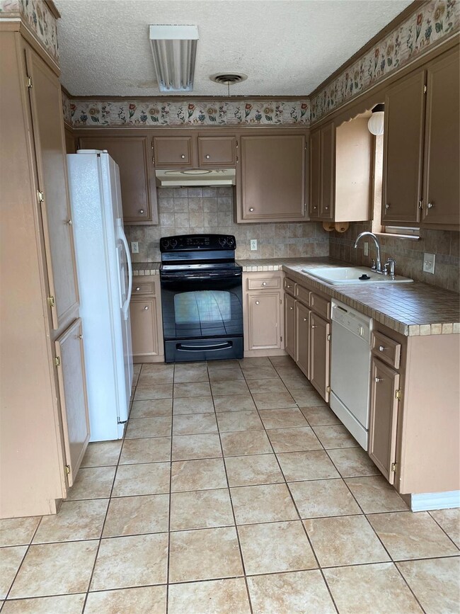 Kitchen featuring light tile patterned floors, dis