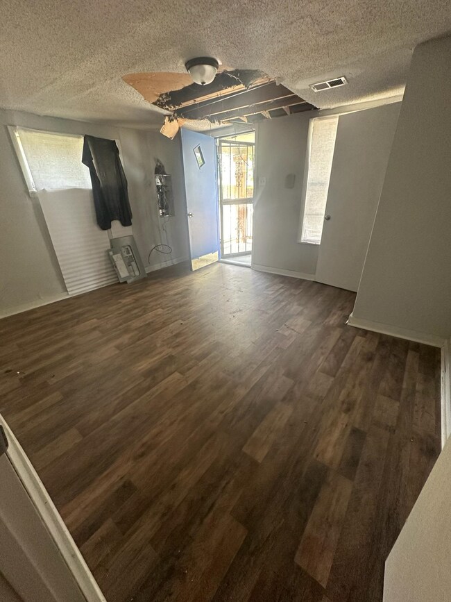 Unfurnished room with wood-type flooring and a tex