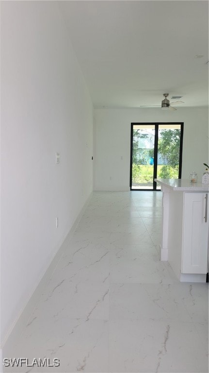 Spare room featuring baseboards, light marble fini