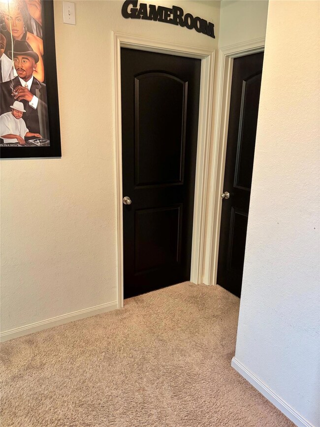 Hall featuring carpet and a textured wall