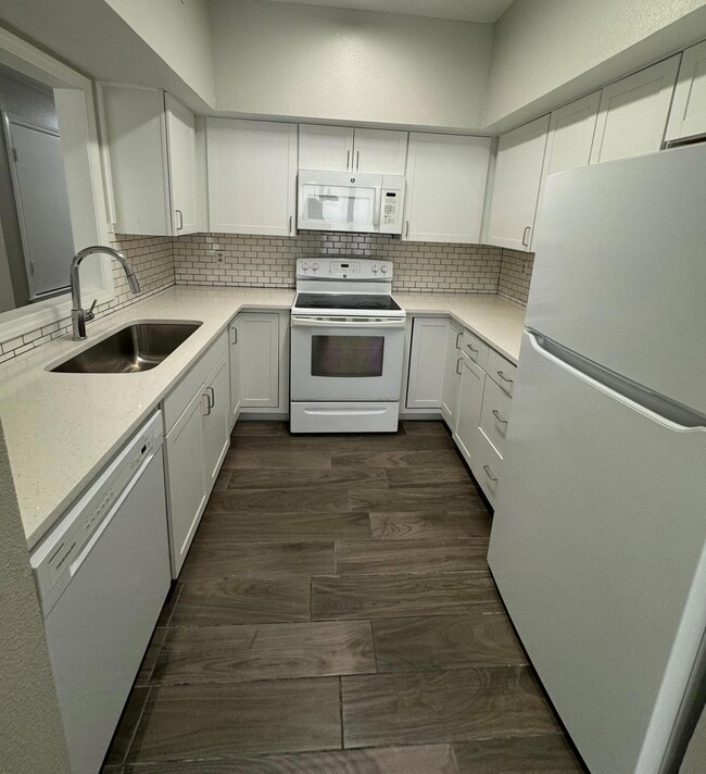 Kitchen with white appliances, tasteful backsplas