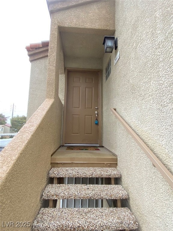 Entrance to property with stucco siding