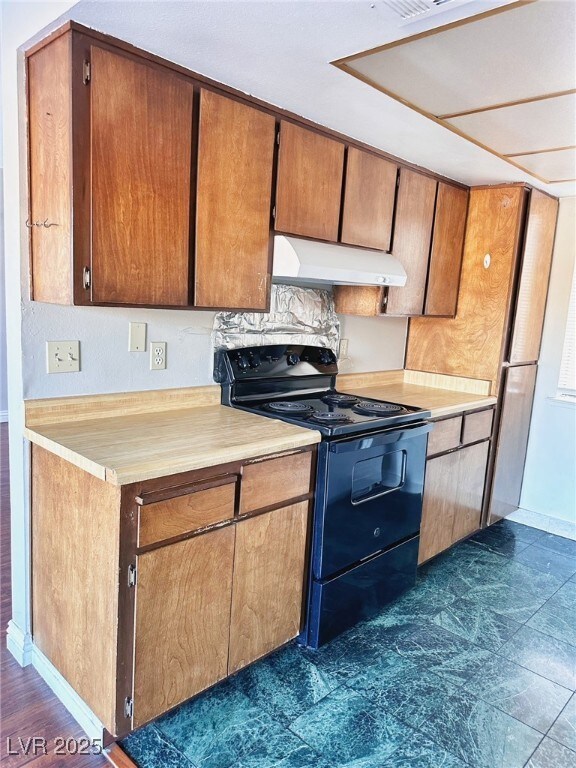 Kitchen featuring electric range, ventilation hood