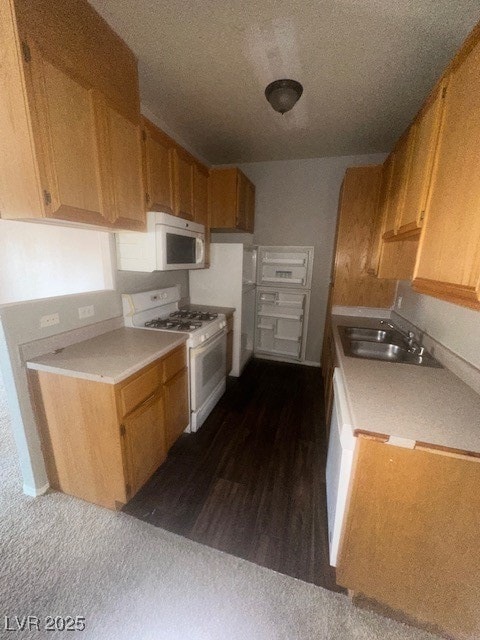 Kitchen featuring stove, a sink, light countertops