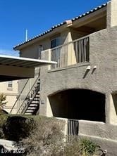 Rear view of property featuring a balcony and stairway