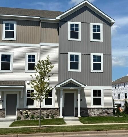 The end unit exterior has striking curb appeal with it's modern design, highlighted by stone accents & clean architectural lines. A charming front patio offers the perfect spot to relax, while the expansive windows fill the home with natural light.
