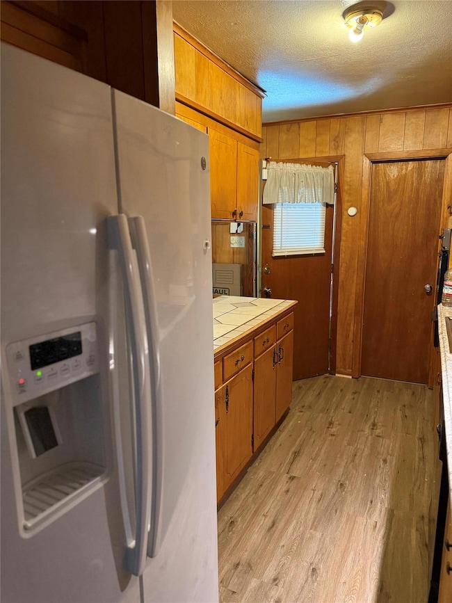 Kitchen with a textured ceiling, light wood finish