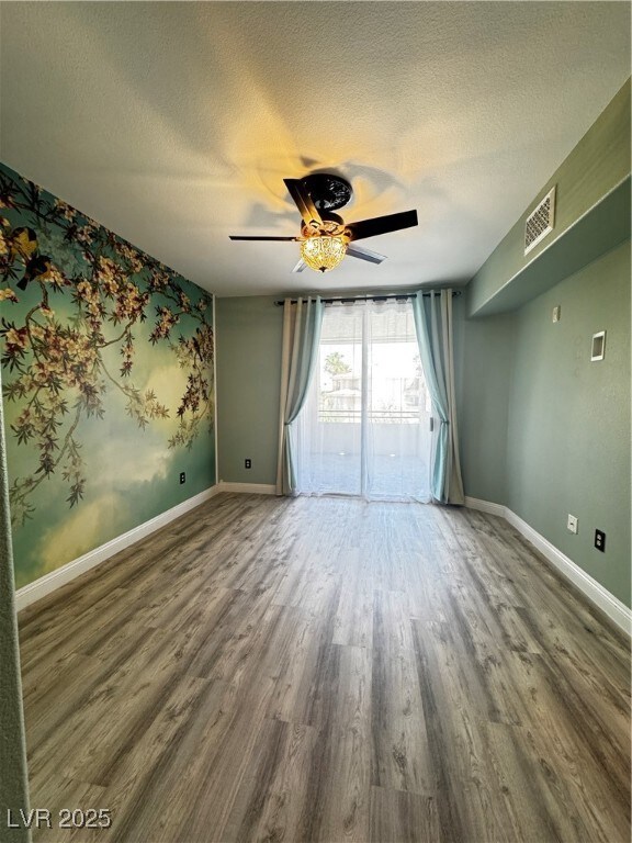 Unfurnished room featuring a ceiling fan, a textur
