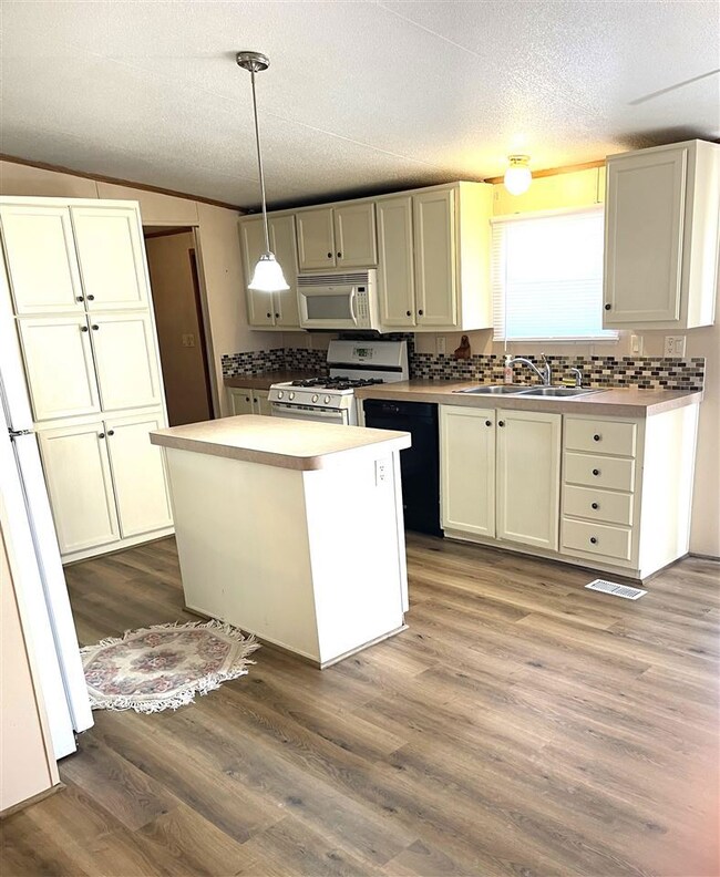 Kitchen has so many cabinets! Lovely island and ac
