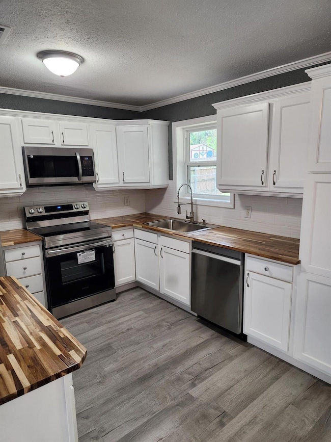 Kitchen featuring range, wood counters, dishwasher