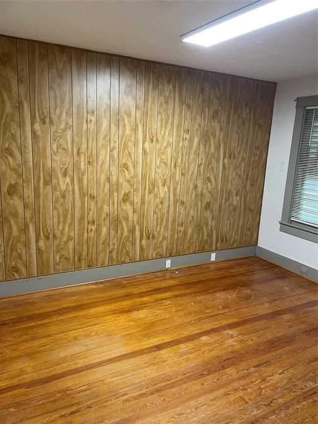 This room features wood paneling on one wall, hard