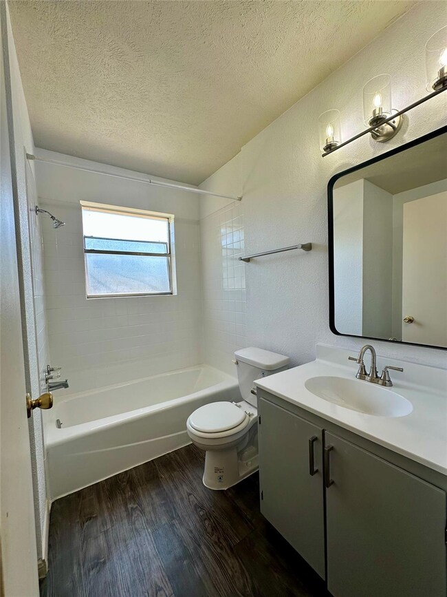 Bathroom featuring wood finished floors, a textur
