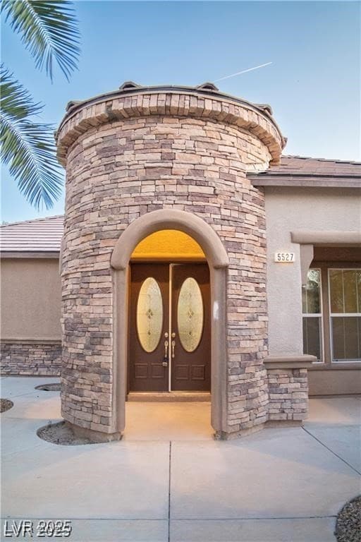 Property entrance with stone siding and stucco sid