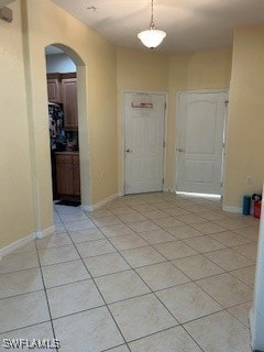 Foyer with arched walkways and light tile patterne