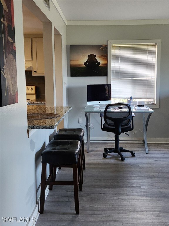 Office area with dark wood-type flooring and baseboards