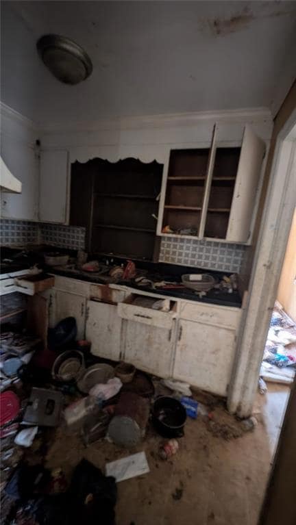 Kitchen with white cabinets, ornamental molding, a