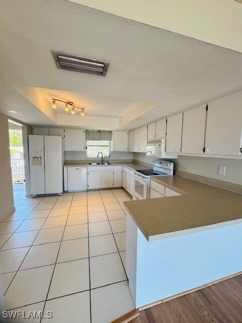 Kitchen featuring a sink, visible vents, a tray ce