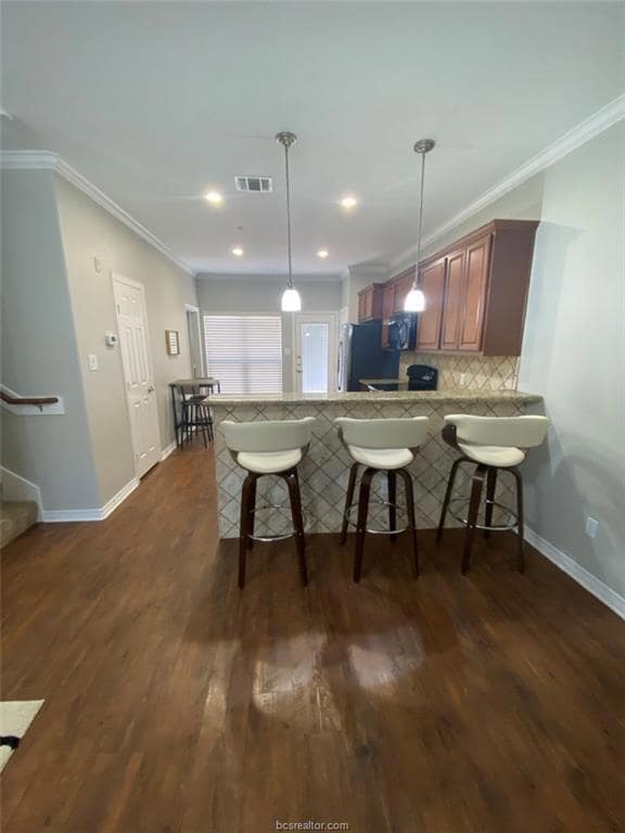 Kitchen featuring visible vents, ornamental moldin