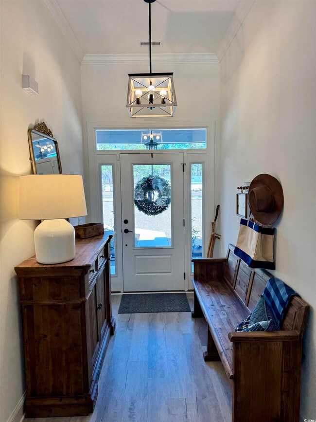 Foyer entrance with a notable chandelier, dark woo