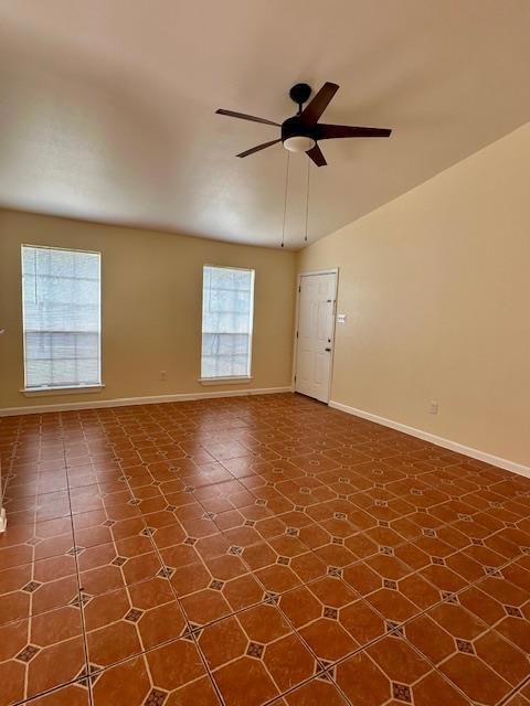 Unfurnished room with ceiling fan and baseboards