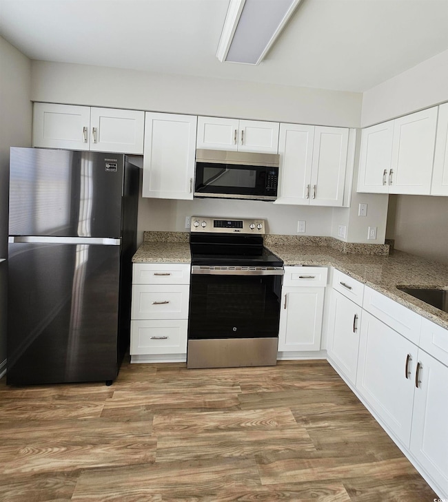 Kitchen featuring light wood-style flooring, a sin