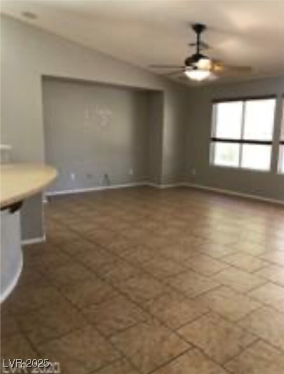 Unfurnished living room with ceiling fan and tile