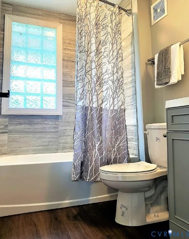 Bathroom with vanity, dark wood-style flooring, and shower / bath combo with shower curtain