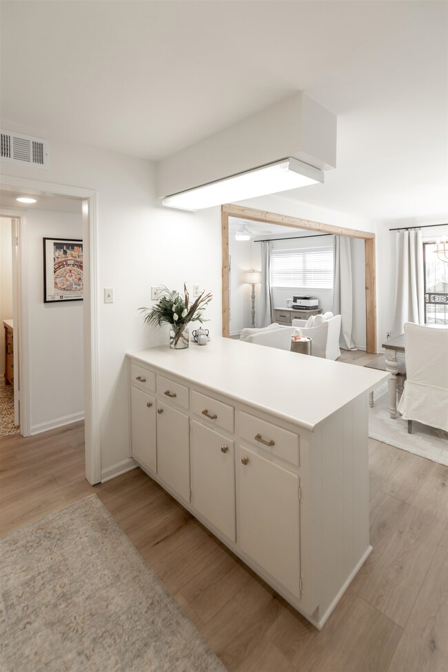 Kitchen featuring kitchen peninsula, light hardwoo