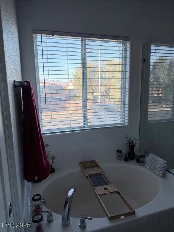 Bathroom featuring a garden tub and plenty of natural light