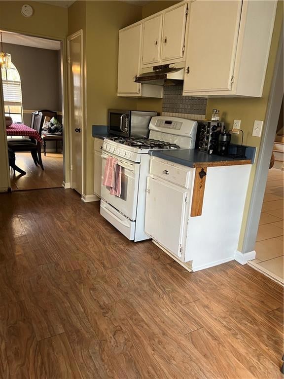 Kitchen featuring ventilation hood, white cabinets