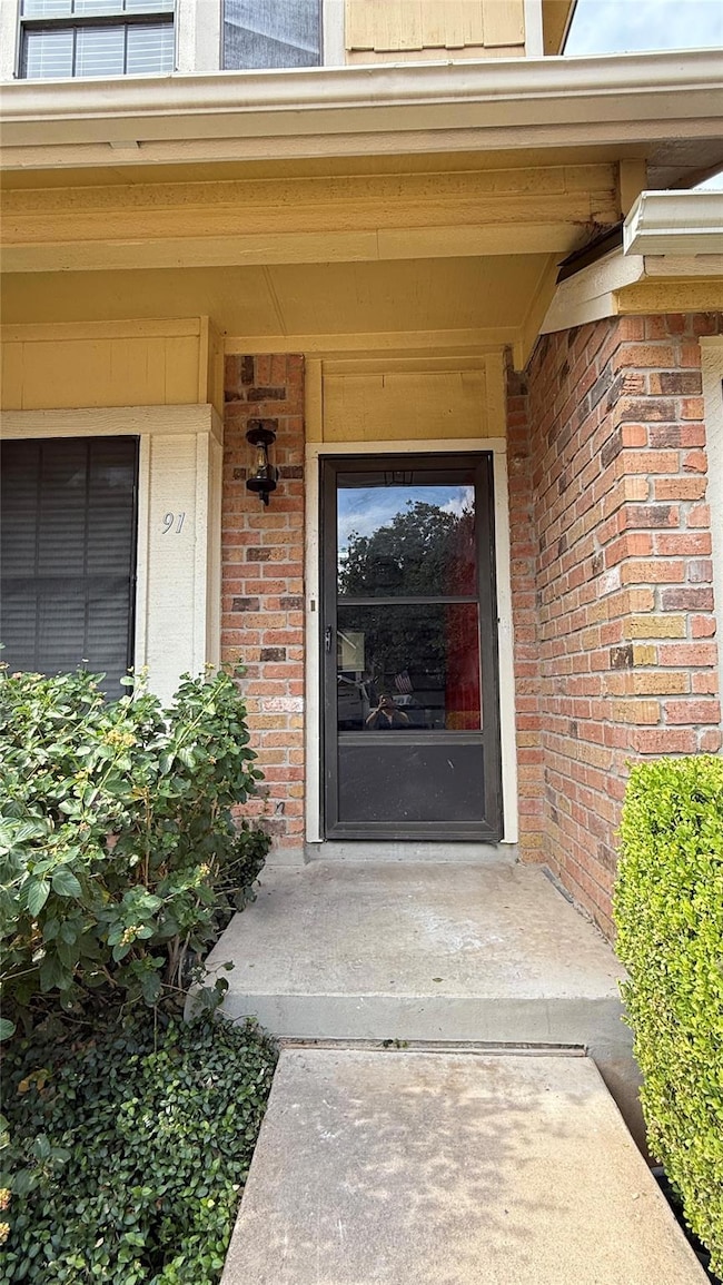 Entrance to property featuring brick siding