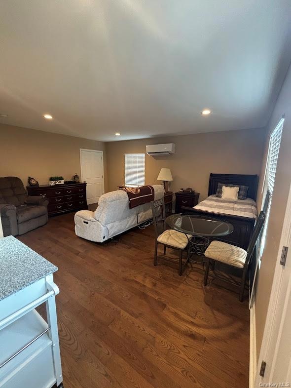 Bedroom with dark wood-style floors, recessed lighting, and multiple windows