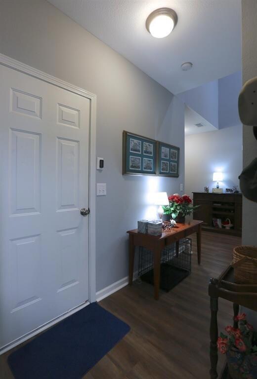 Entrance foyer with baseboards and wood finished floors