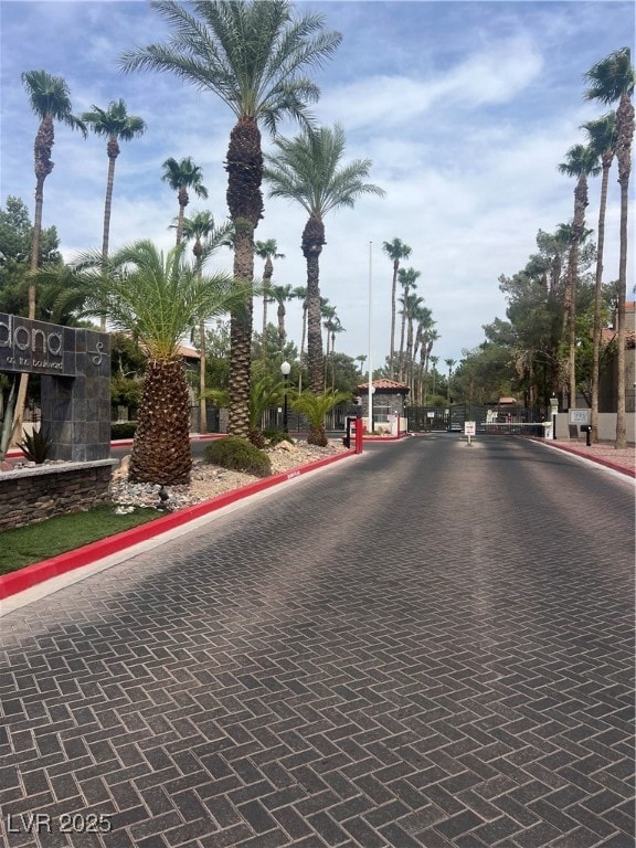View of decorative road with curbs and a gated entry