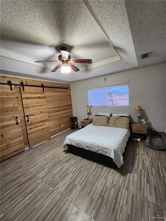 Bedroom featuring ceiling fan, wood-type flooring, and a textured ceiling