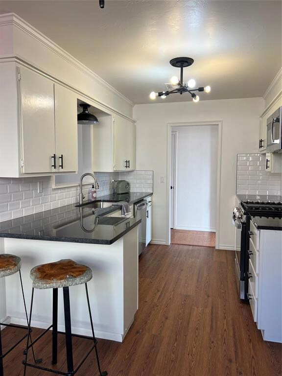 Kitchen with an inviting chandelier, dark wood-typ