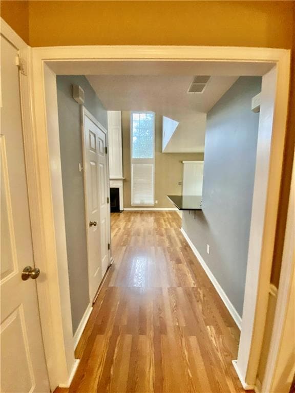 Hall with light wood finished floors and baseboards