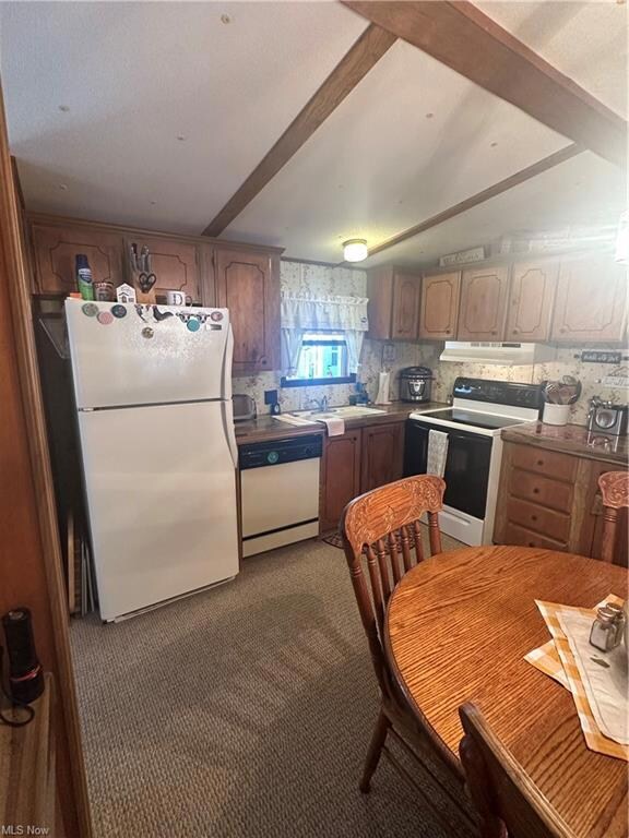 Kitchen featuring backsplash, range, beam ceiling,