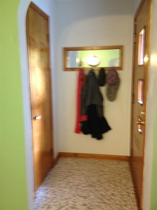 Arched doorway foyer with guest closet.