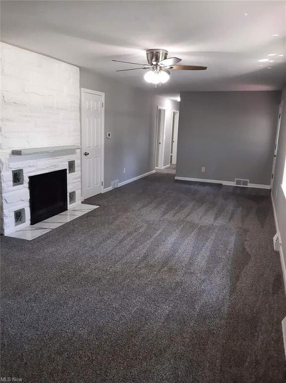 Living room featuring a fireplace, dark carpet, an