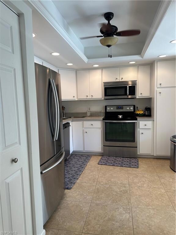Kitchen featuring white cabinetry, range, fridge, 